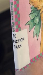 The spine and cover of the book "Junie B. Jones is (almost) a Flower Girl" focused on the spine label. The spine label reads "EC FICTION PARK."