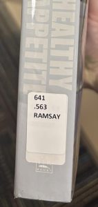 A closeup of the spine on the book "Gordon Ramsay's Healthy Appetite," focusing on the spine label. The spine label reads "641.563 RAMSAY."