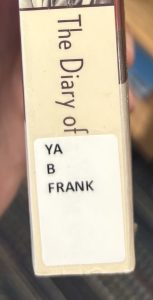 A closeup of the spine on the book "The Diary of a Young Girl," focusing on the spine label. The spine label reads "YA B FRANK."