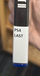 A closeup of the spine on the video game "The Last of Us Part II," focusing on the spine label. The spine label reads "PS4 LAST."