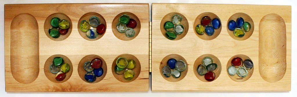 a wooden board with shallow cavities filled with colorful glass stones